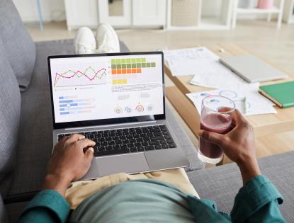 business man working on couch with laptop showing performance dashboard