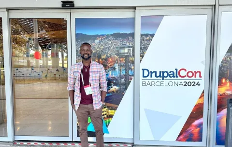 Responsab founder posing in front of the DrupalCon entrance in Barcelona